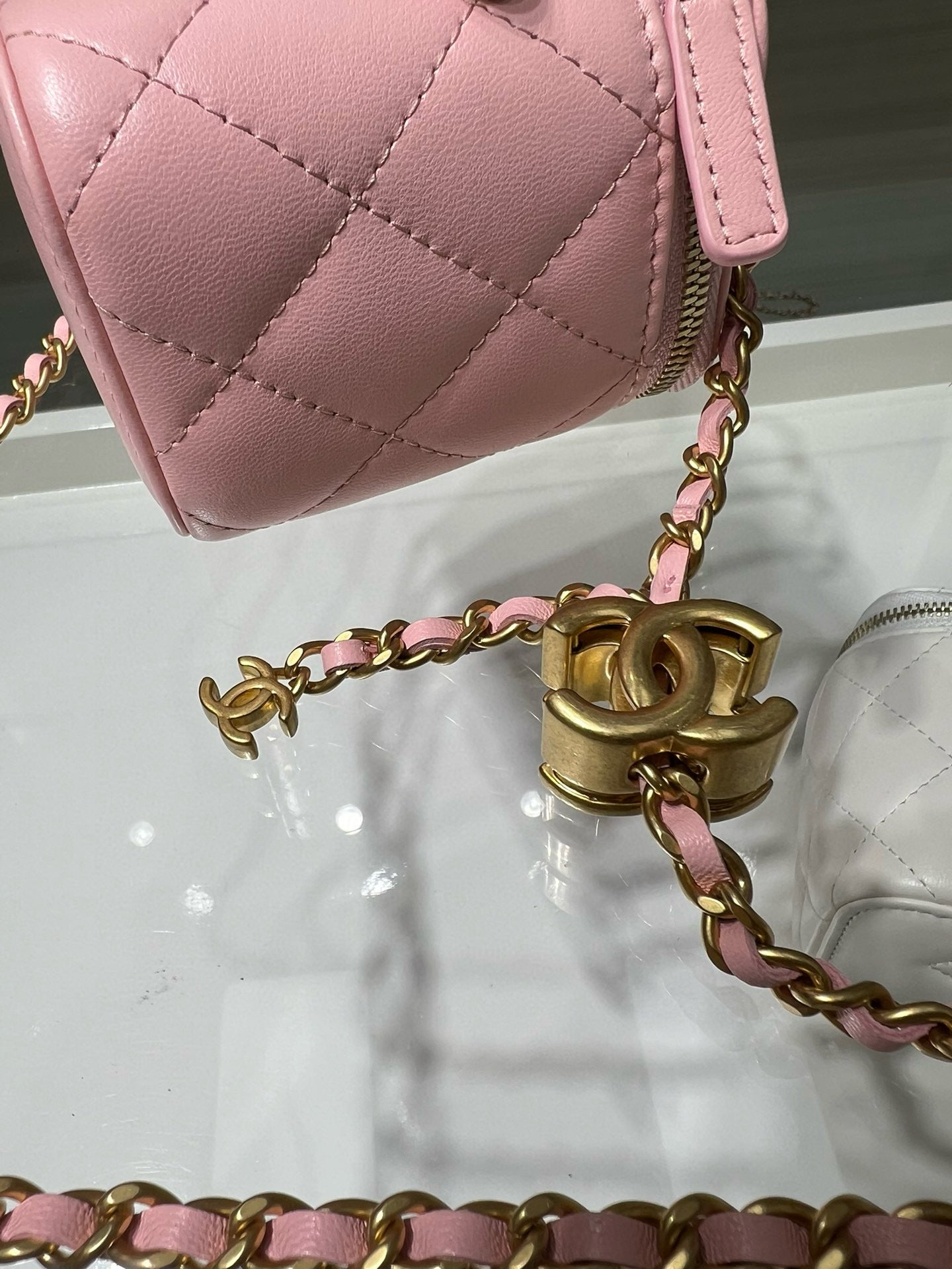 Pink Chanel quilted mini bag with gold clasp and chain strap detail.