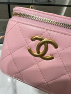 Pink Chanel mini bag with quilted design, gold CC emblem, and zip top.