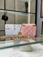 Pink quilted mini bag with gold chain crossbody strap and front zipper pocket.
