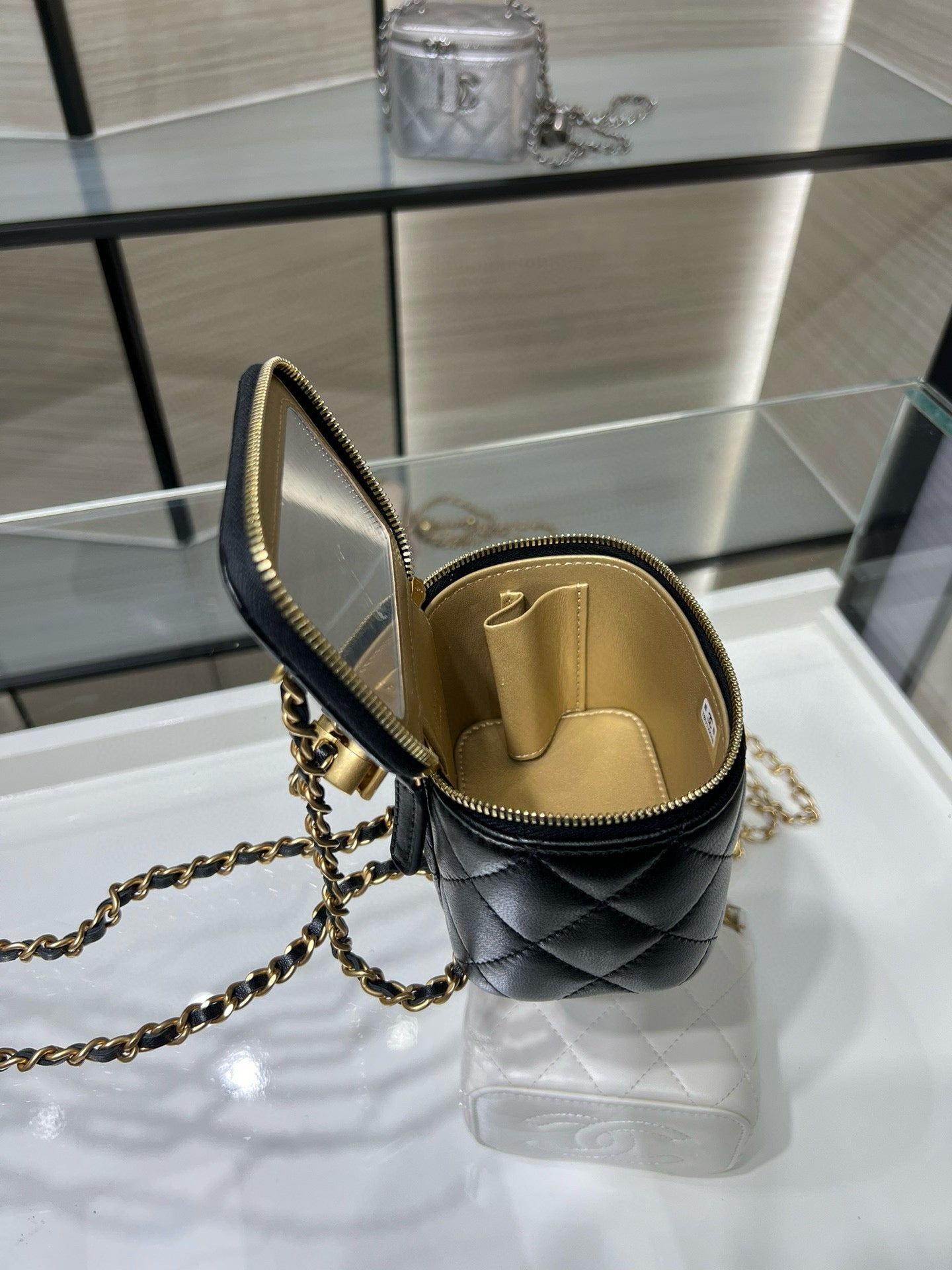 Chanel mini bag with open top view, black quilted leather and gold zipper trim