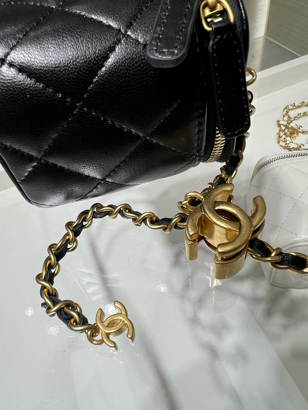 Chanel bag close-up: black quilted leather with gold chain and logo hardware