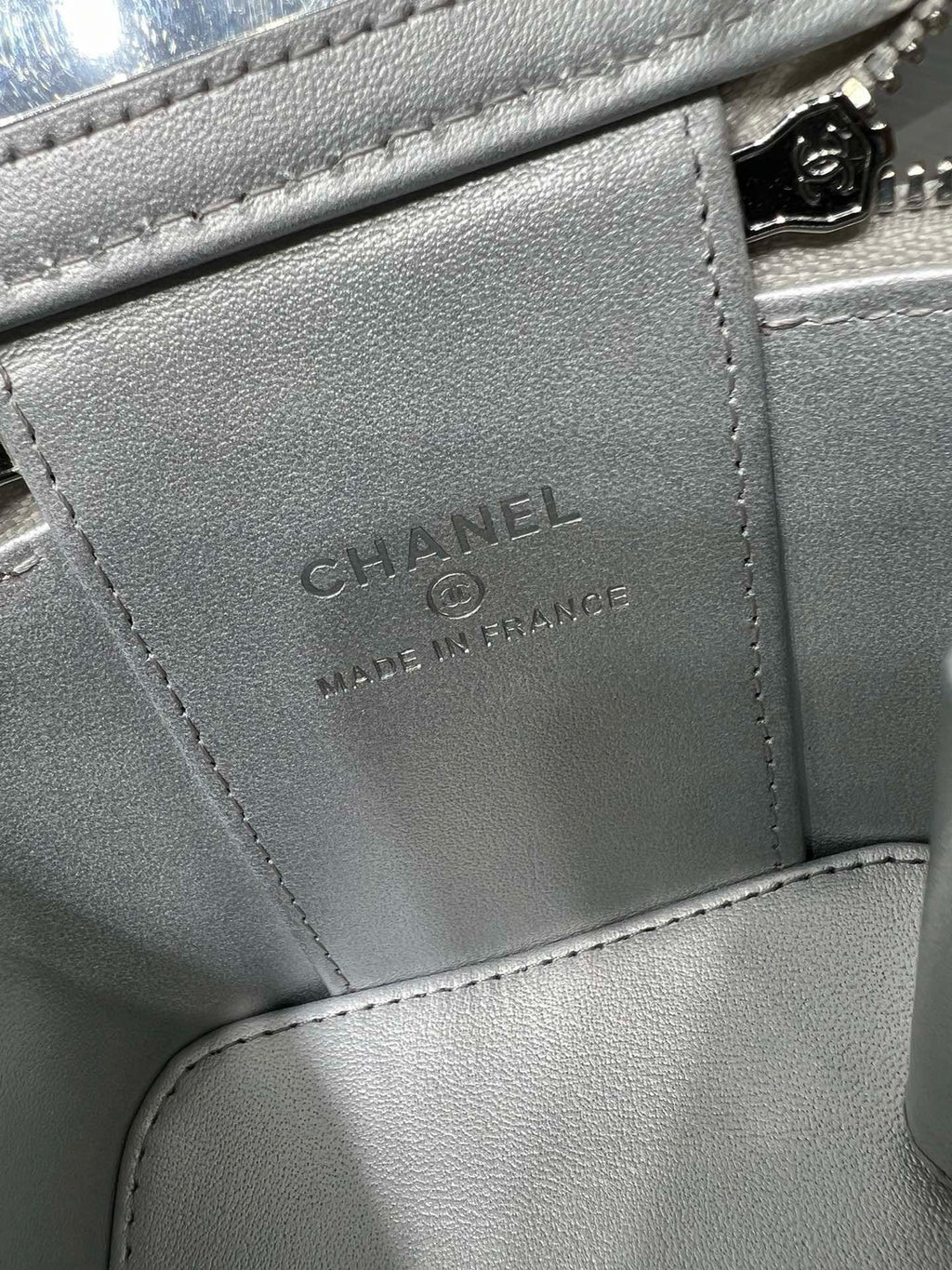 Silver leather bag interior label: CHANEL, Made in France, on stitched pocket