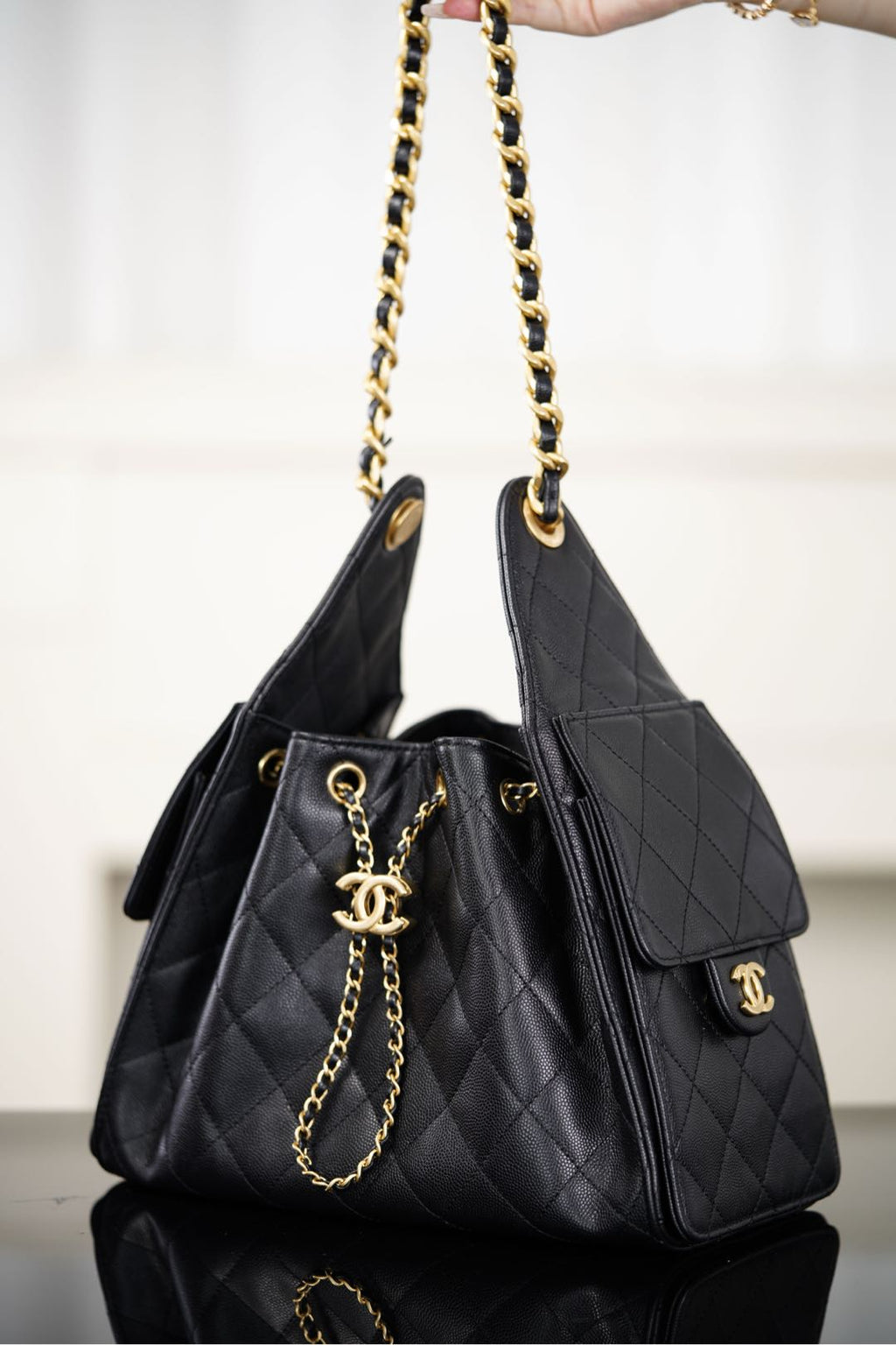 Black Chanel quilted bucket bag with side tag logo and gold chain handle