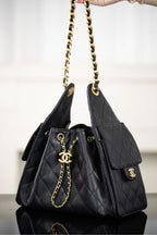 Black Chanel quilted bucket bag with side tag logo and gold chain handle