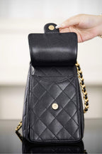 Black Chanel quilted leather bag with hinged top flap and gold snap hardware