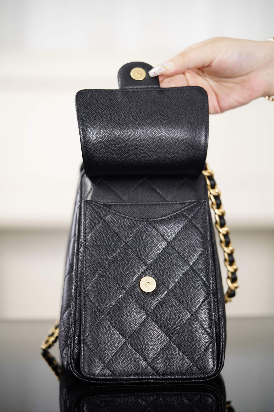 Black Chanel quilted leather bag with hinged top flap and gold snap hardware