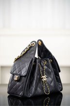 Black Chanel quilted bucket bag with side flap and gold chain strap