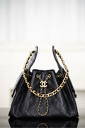Black Chanel quilted bucket bag with gold chain straps and CC logo front