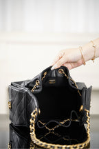 Black Chanel quilted bucket bag interior view with gold chain and zipper pocket