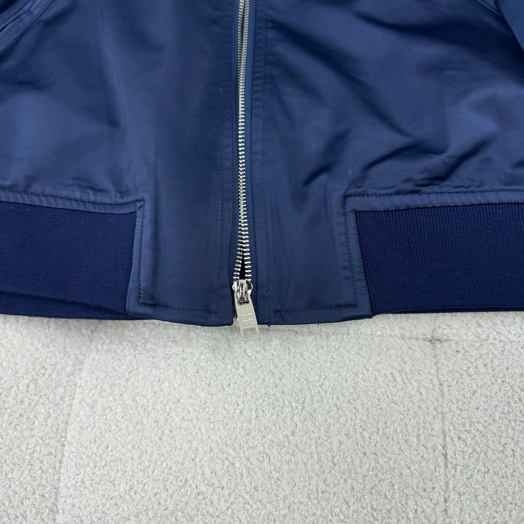 Dark blue bomber jacket with front zip and side zip pockets plus ribbed hem