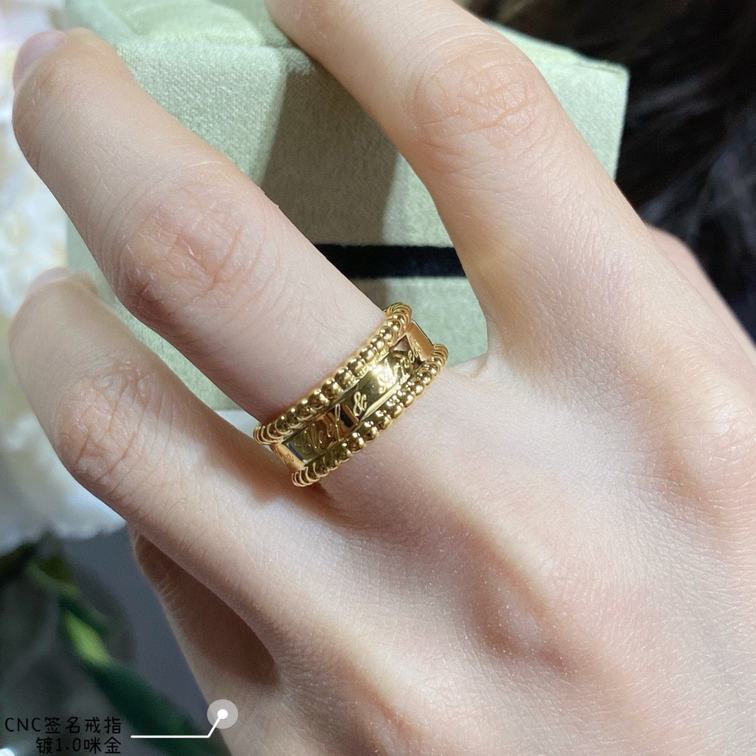 Van Cleef & Arpels gold band ring with textured engravings and small stones on hand