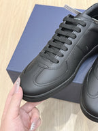 Black lace-up low-top sneakers with panel stitching and textured rubber sole