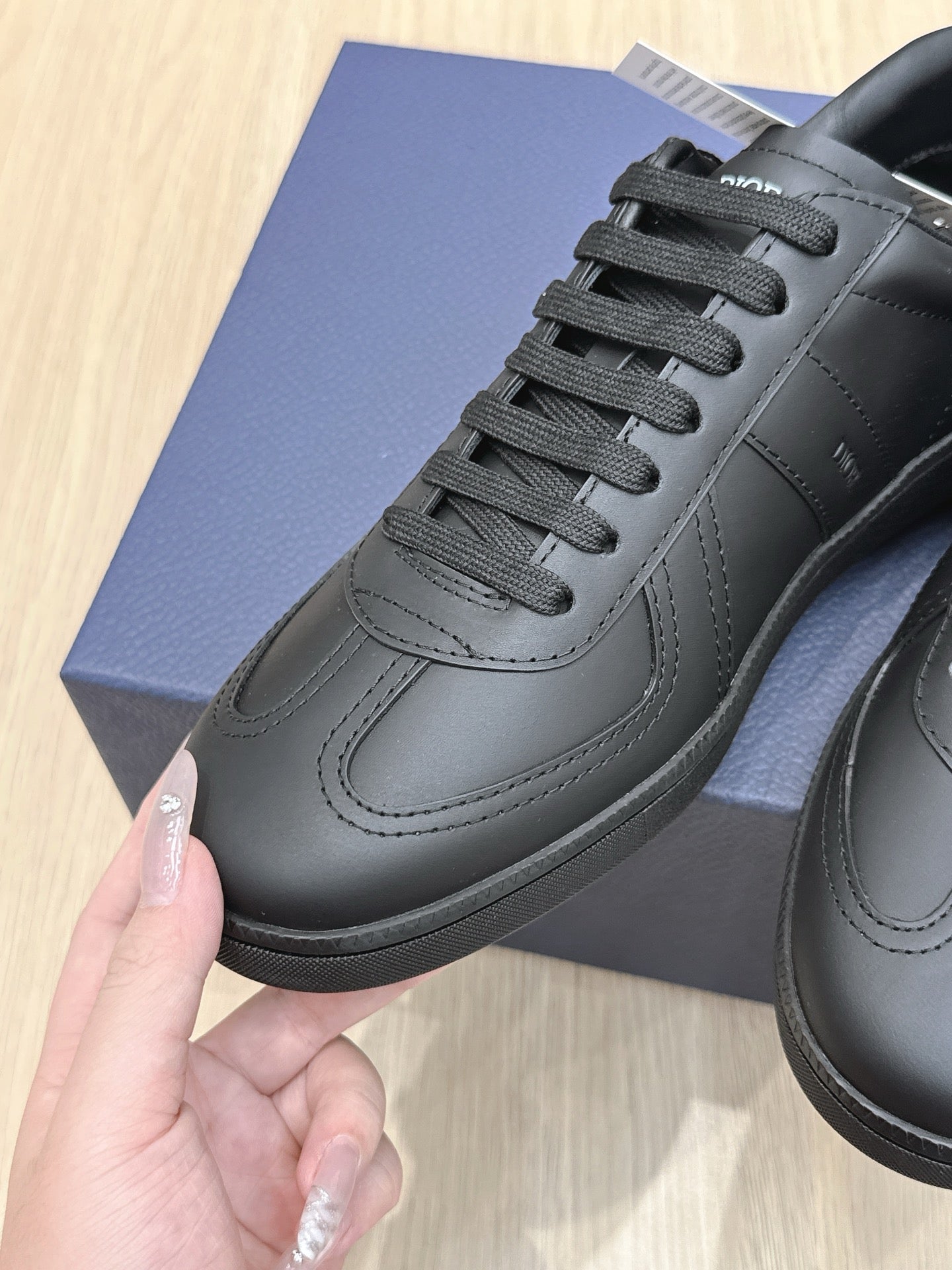 Black lace-up low-top sneakers with panel stitching and textured rubber sole