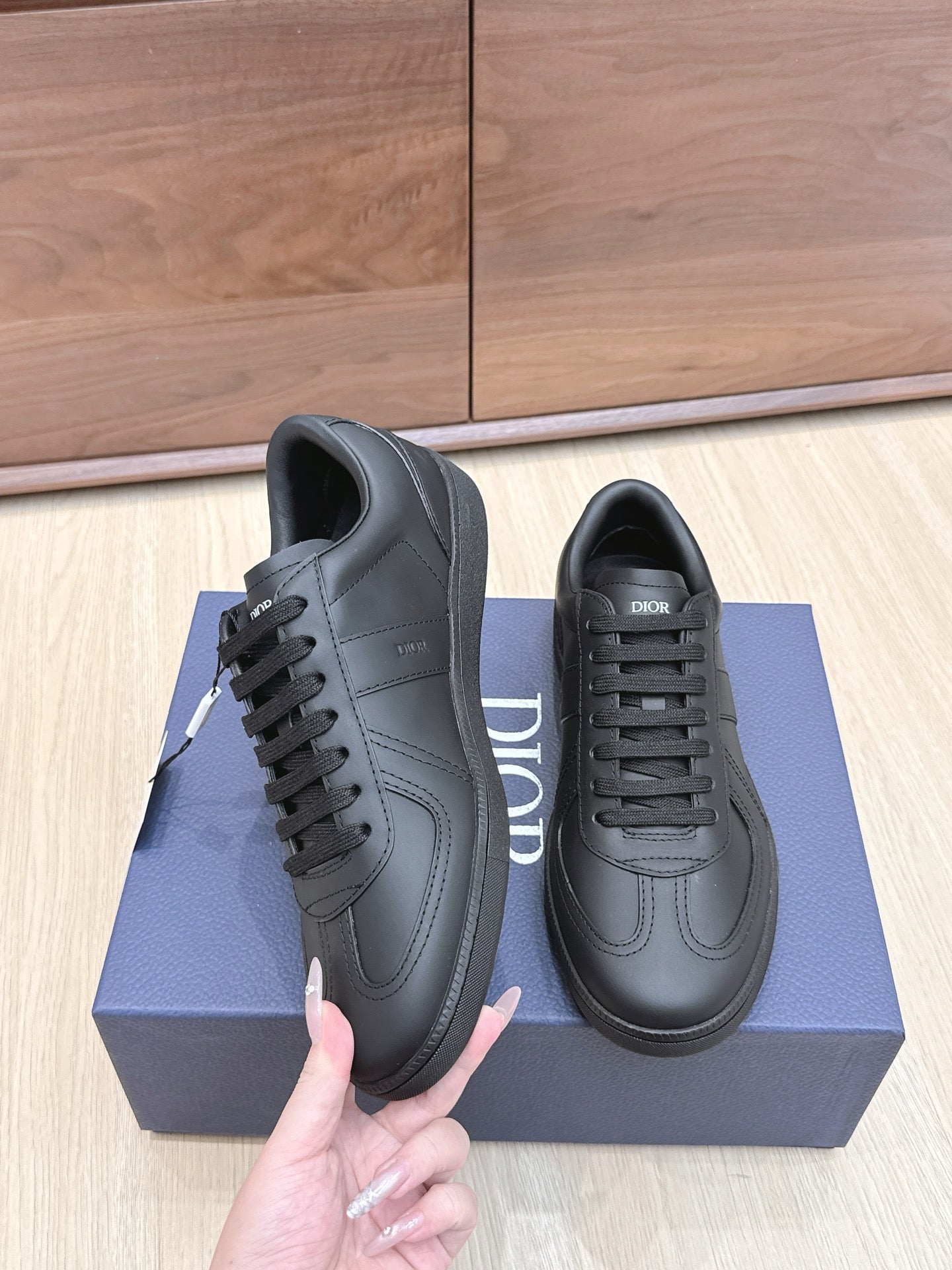 Black low-top sneakers with lace-up closure and Dior branding on tongue on box