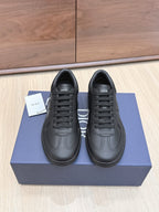 Black low-top leather sneakers with lace-up front and Dior logo on tongue