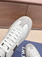 Close-up of white lace-up sneaker toe and textured gray overlay on sole.