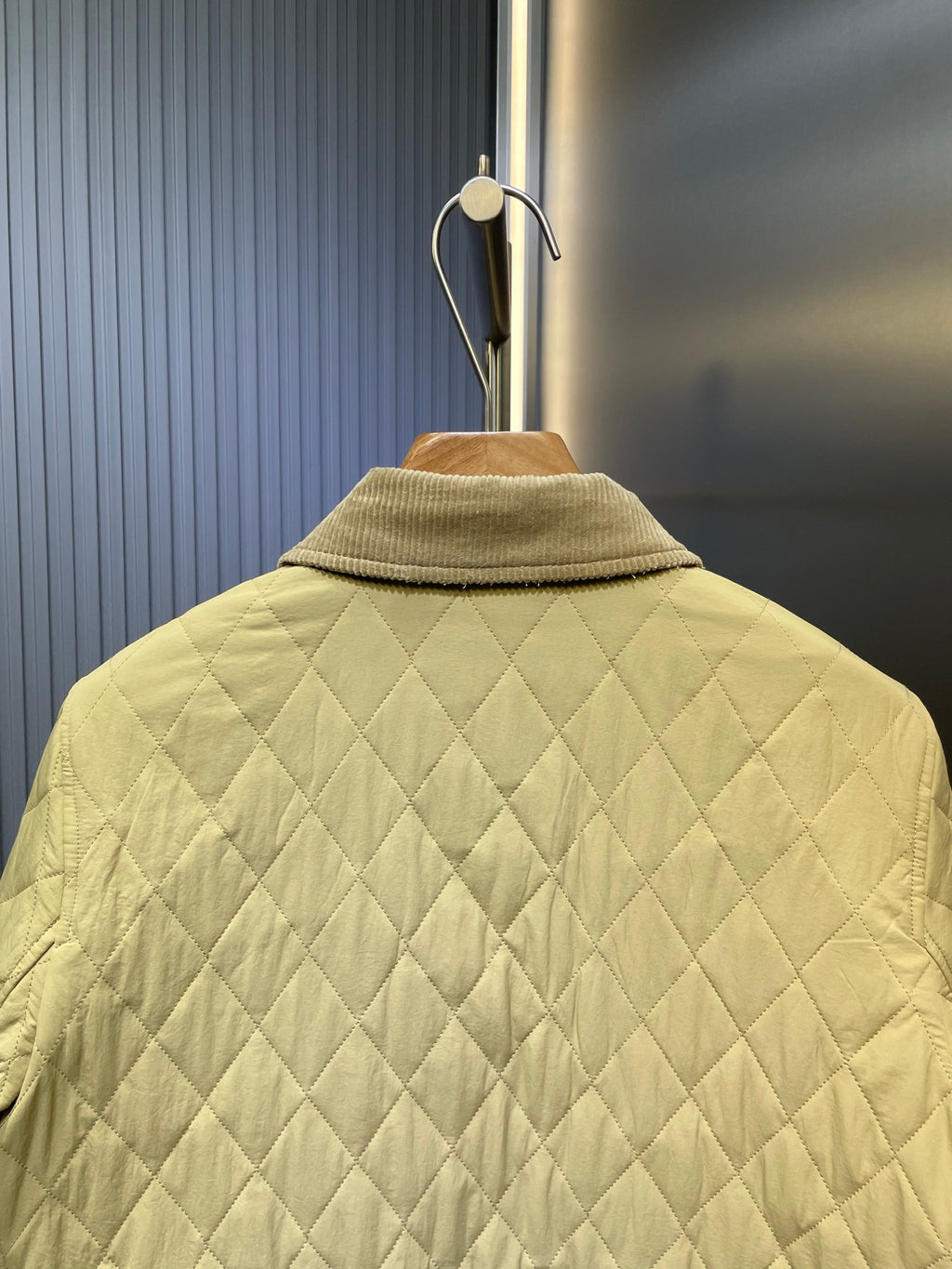 Yellow quilted jacket back with stand collar and diamond stitching.
