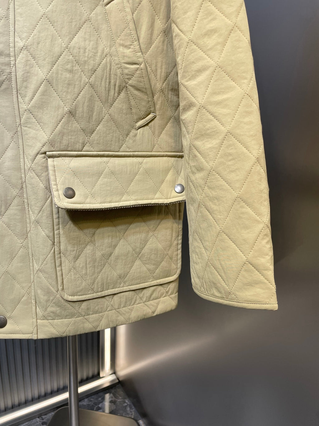 Yellow quilted jacket with flap chest pocket and strap detail, buttoned front.