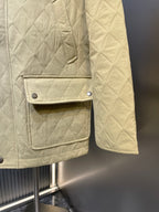 Yellow quilted jacket with flap chest pocket and strap detail, buttoned front.