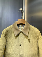 Yellow quilted jacket with corduroy collar, button placket, and Burberry crest on chest.