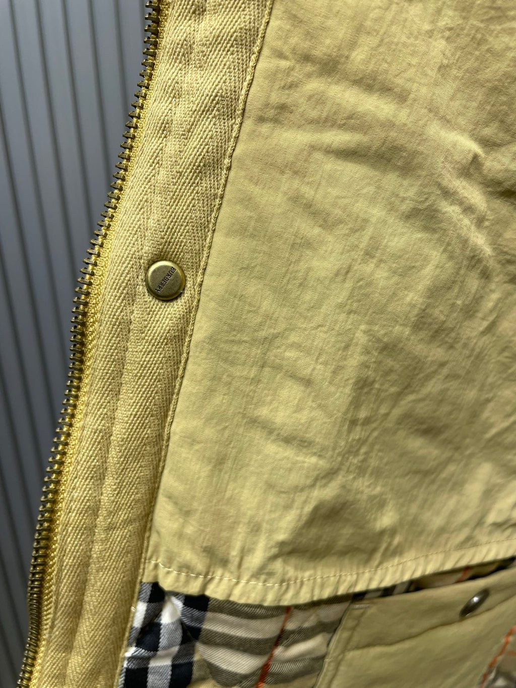 Long quilted coat zipper close-up with plaid lining