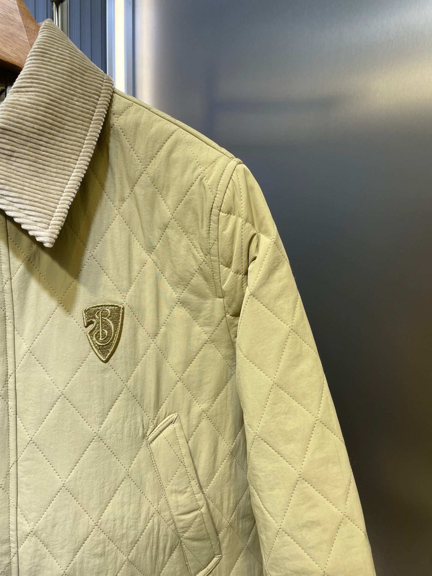 Yellow quilted jacket with Burberry crest patch and diamond stitching.