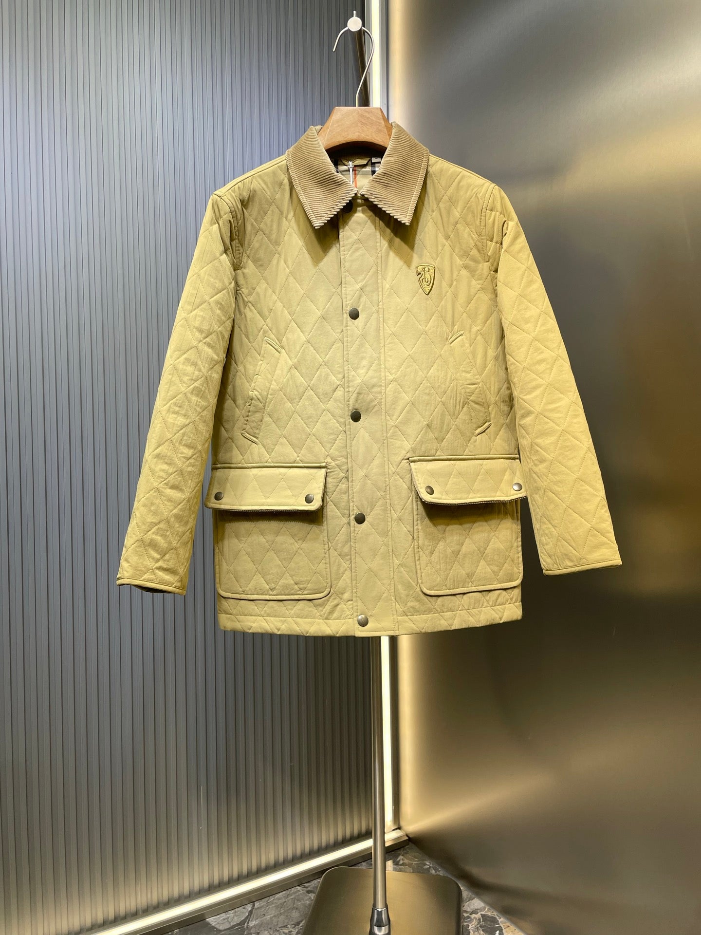 Yellow quilted jacket with snap front, flap pockets, and corduroy-style collar (Burberry).