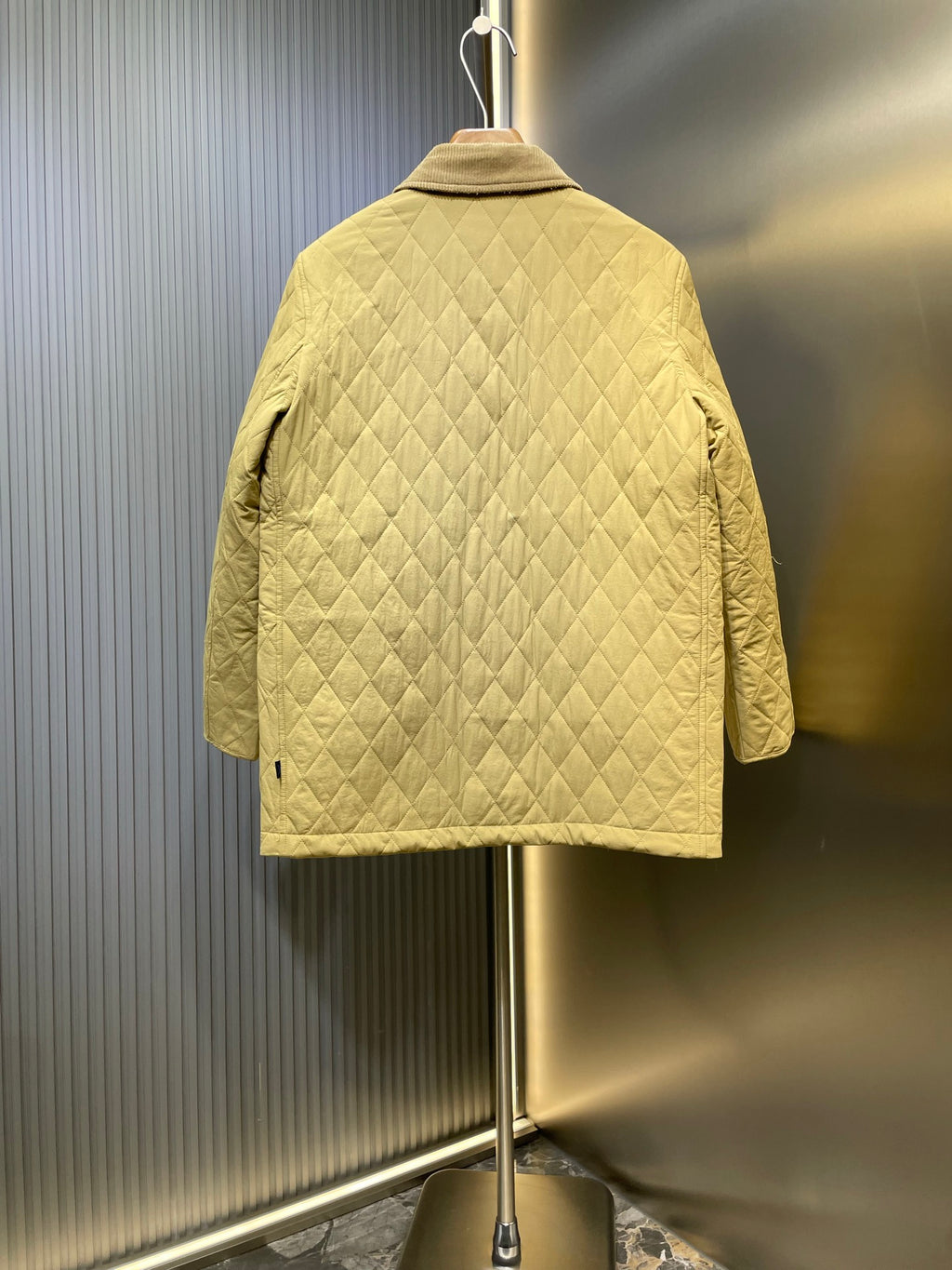 Yellow quilted jacket back view with stand collar and diamond quilting.