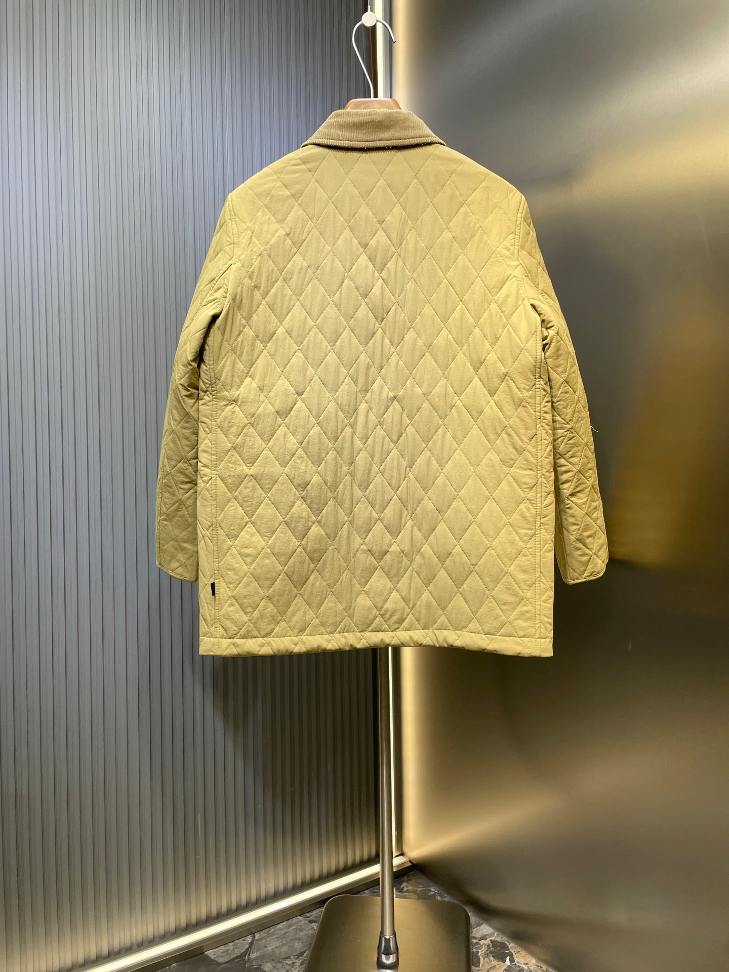 Yellow quilted jacket back view with stand collar and diamond quilting.