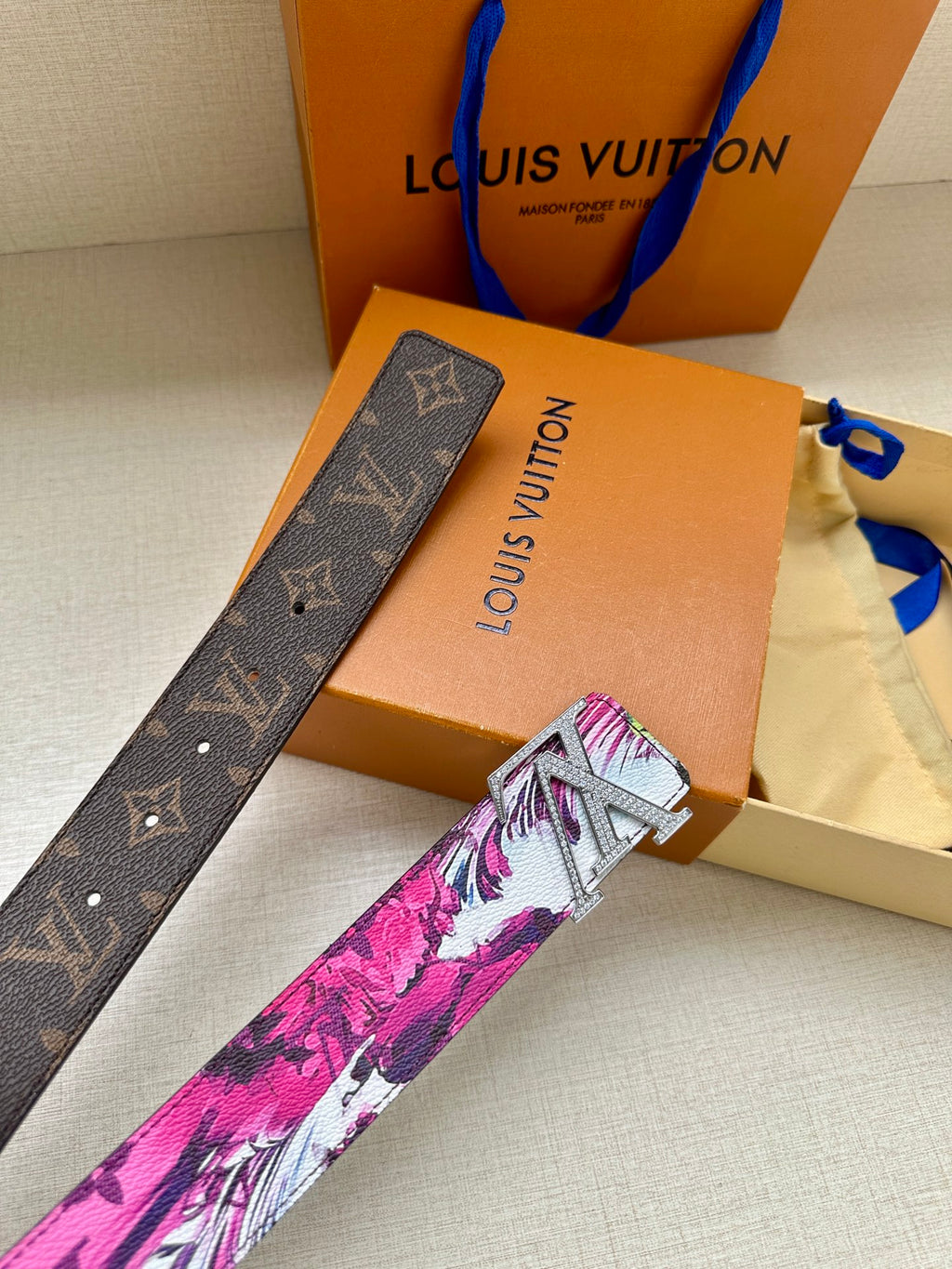Louis Vuitton belt with pink floral strap and silver LV buckle, with dark monogram end.