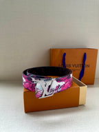 Louis Vuitton belt with pink floral canvas strap and silver LV buckle, front view.
