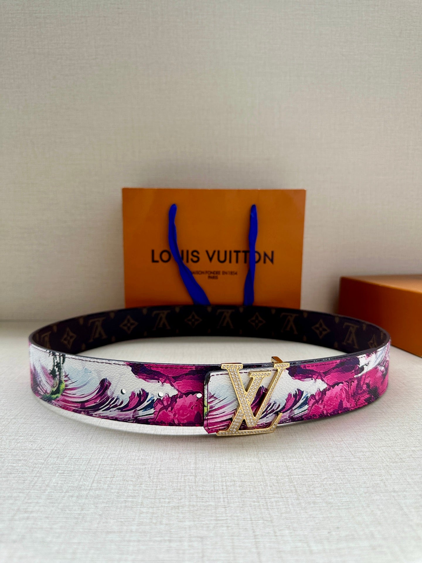 Louis Vuitton belt with pink floral canvas strap and silver LV buckle.