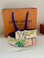 Louis Vuitton belt on dark backing with pink floral pattern and silver LV buckle centerpiece