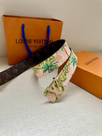 Louis Vuitton belt angled view: pink floral strap and silver LV buckle over dark band
