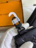 Louis Vuitton bag hardware with strap and key clasp attached to dark leather accessory