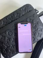 Louis Vuitton monogram crossbody bag, dark leather texture with phone in the front pocket