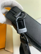 Louis Vuitton strap clasp with 'Louis Vuitton' text on dark leather, metal hardware