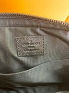 Louis Vuitton bag interior label on dark fabric lining beneath the zipper seam.