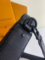 Louis Vuitton bag in dark monogram leather with textured strap and metal ring attachment.