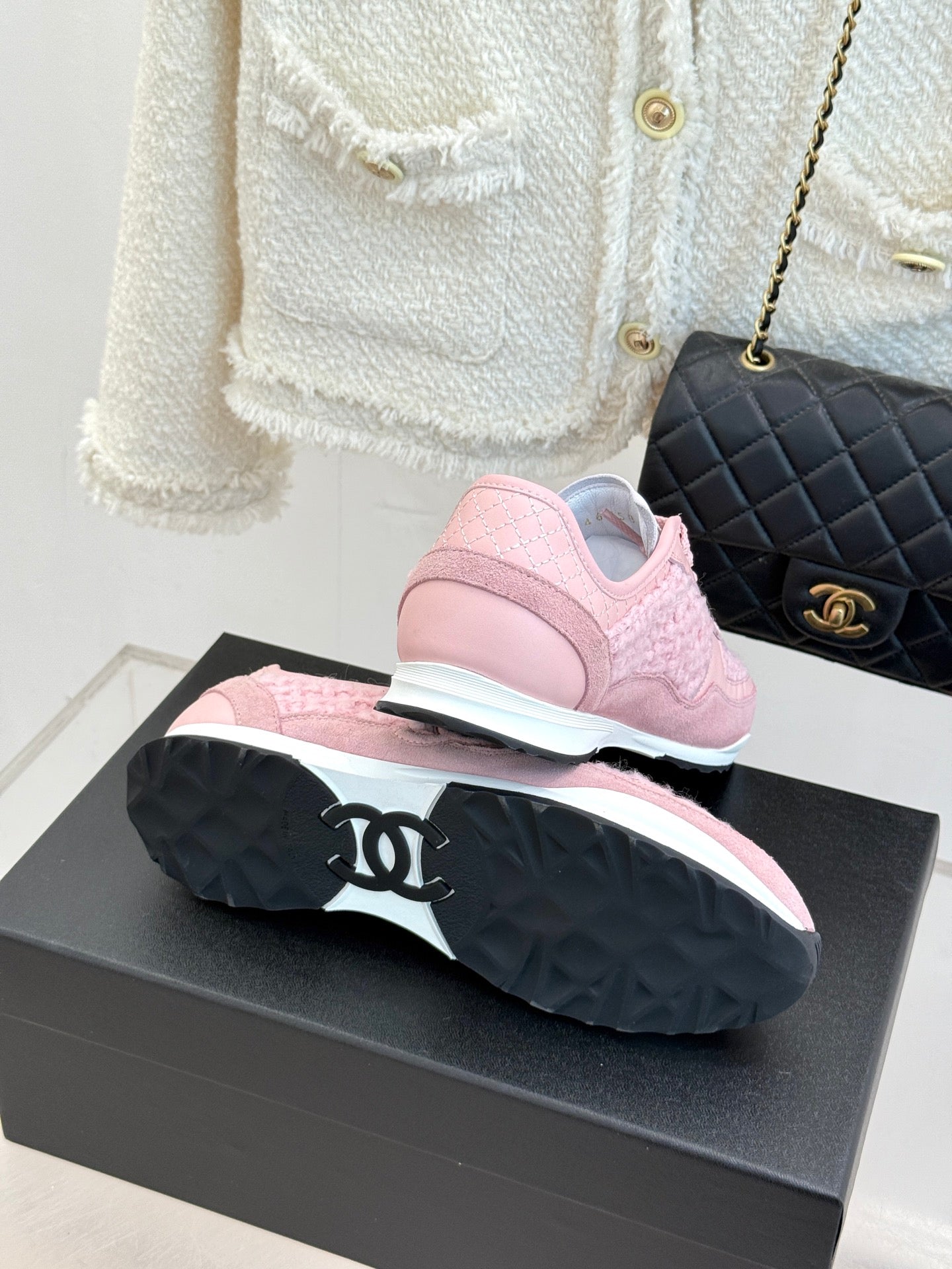 Pink Chanel sneakers sole view with chunky tread, on black display box