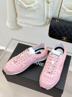 Pink Chanel low-top sneakers, pair shown front and side on black box