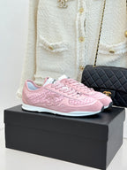 Pink Chanel low-top sneakers with lace-up front, on black display box