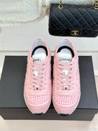 Pink Chanel low-top sneakers with front logo and lace-up closure on black box