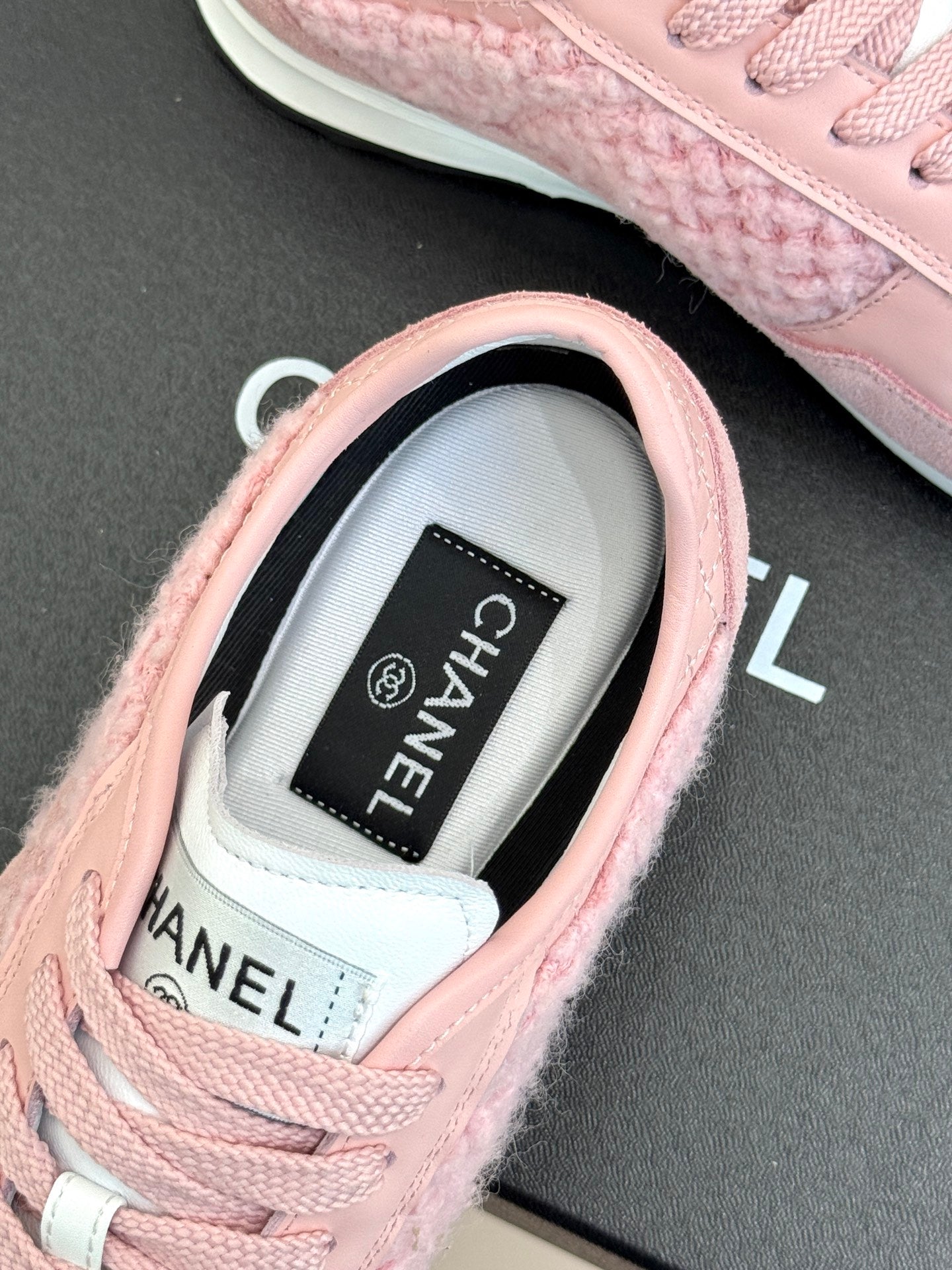 Pink Chanel sneaker close-up of tongue label and lace-up collar