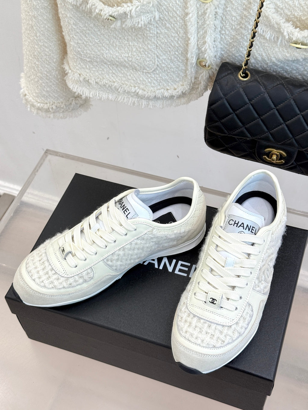 White Chanel sneakers pair with lace-up vamps and CHANEL tongue label on box