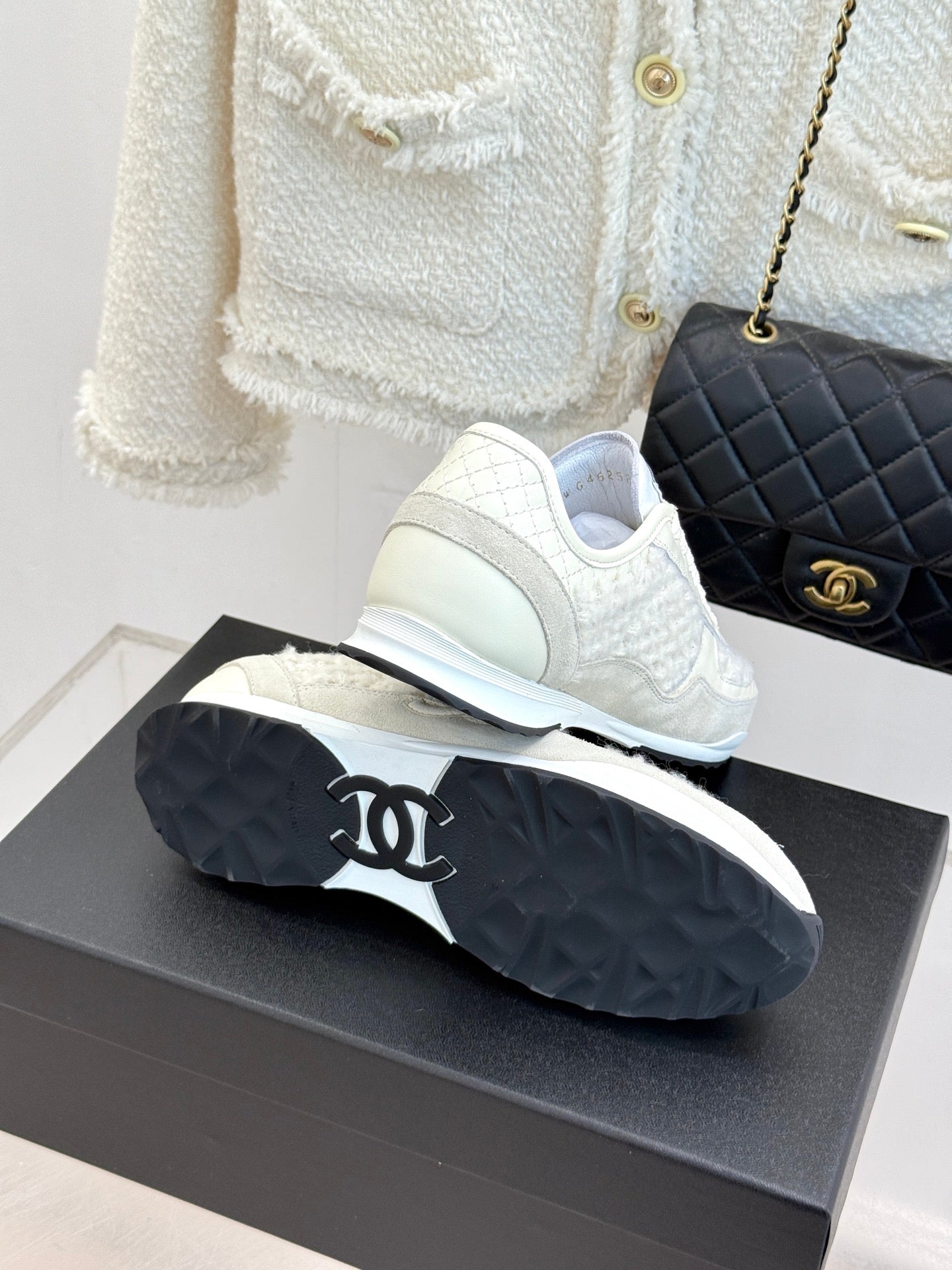 White Chanel sneakers outsole view, tread pattern with black rubber sole on box