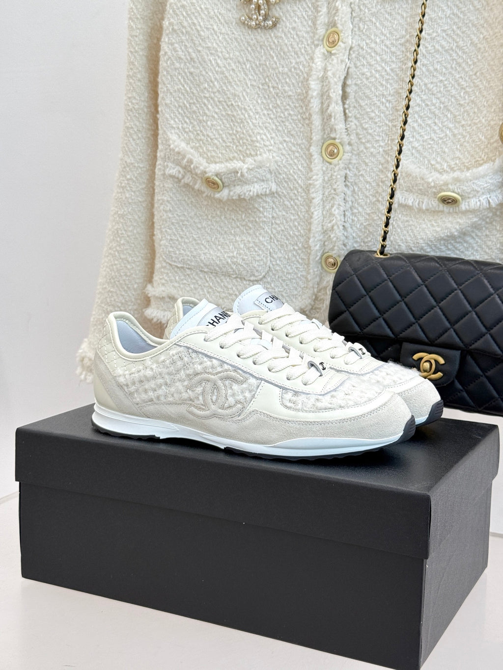 White Chanel low-top sneakers on box, textured fabric and lace-up front