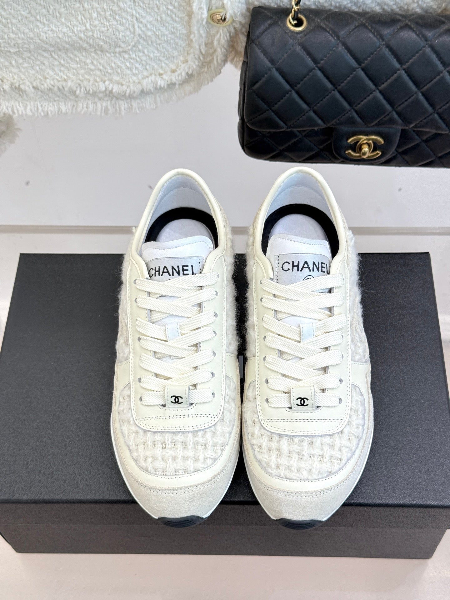 White Chanel sneakers front view, lace-up design with CHANEL heel patch