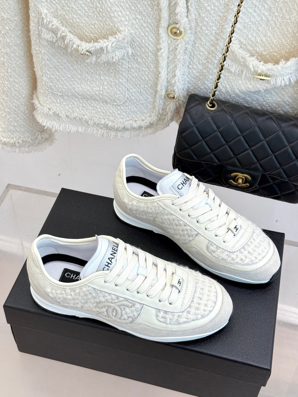 White Chanel sneakers side view, lace-up with logo detailing on textured uppers