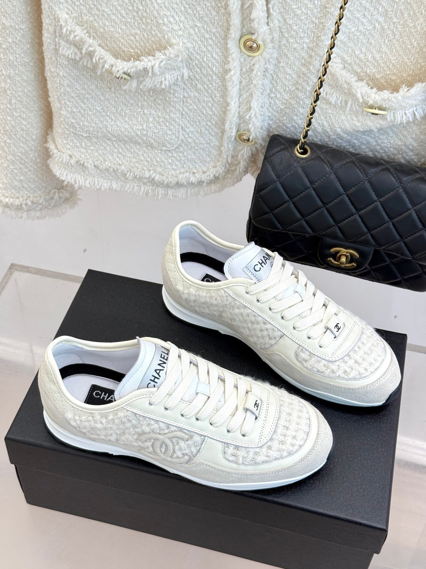 White Chanel sneakers side view, lace-up with logo detailing on textured uppers